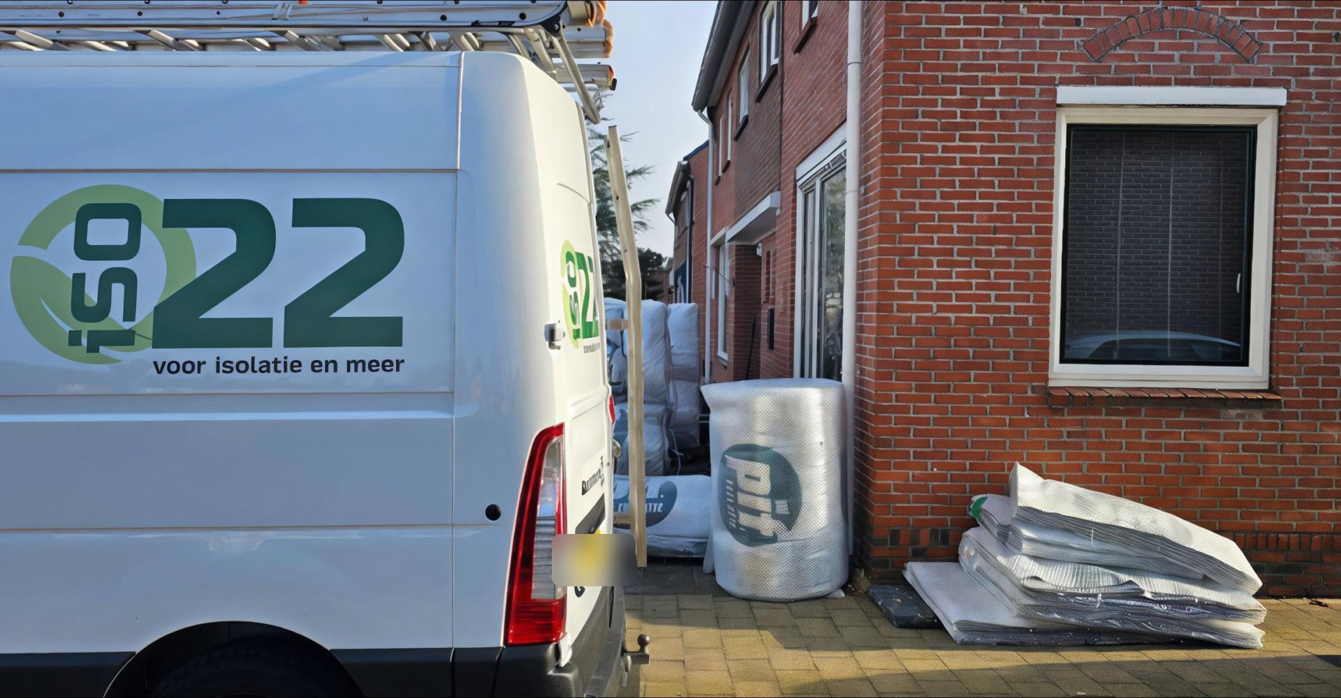 De bus van iSO22 met isolatiemateriaal bij een woning